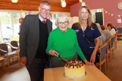 Ida Innes cuts the celebratory cake at Harriet Court watched by Michael Newey and Joanne Grimes sm