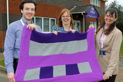 Zoe Tinkler of Vison Norfolk centre presents one of the blankets to Kieran Gamble and Dawnmarie Bird of The Purfleet Trust sm